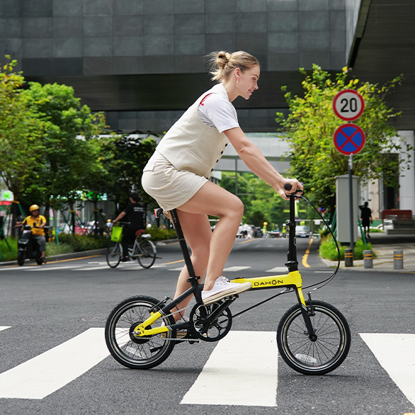 kobieta niosąca lekki rower elektryczny składany