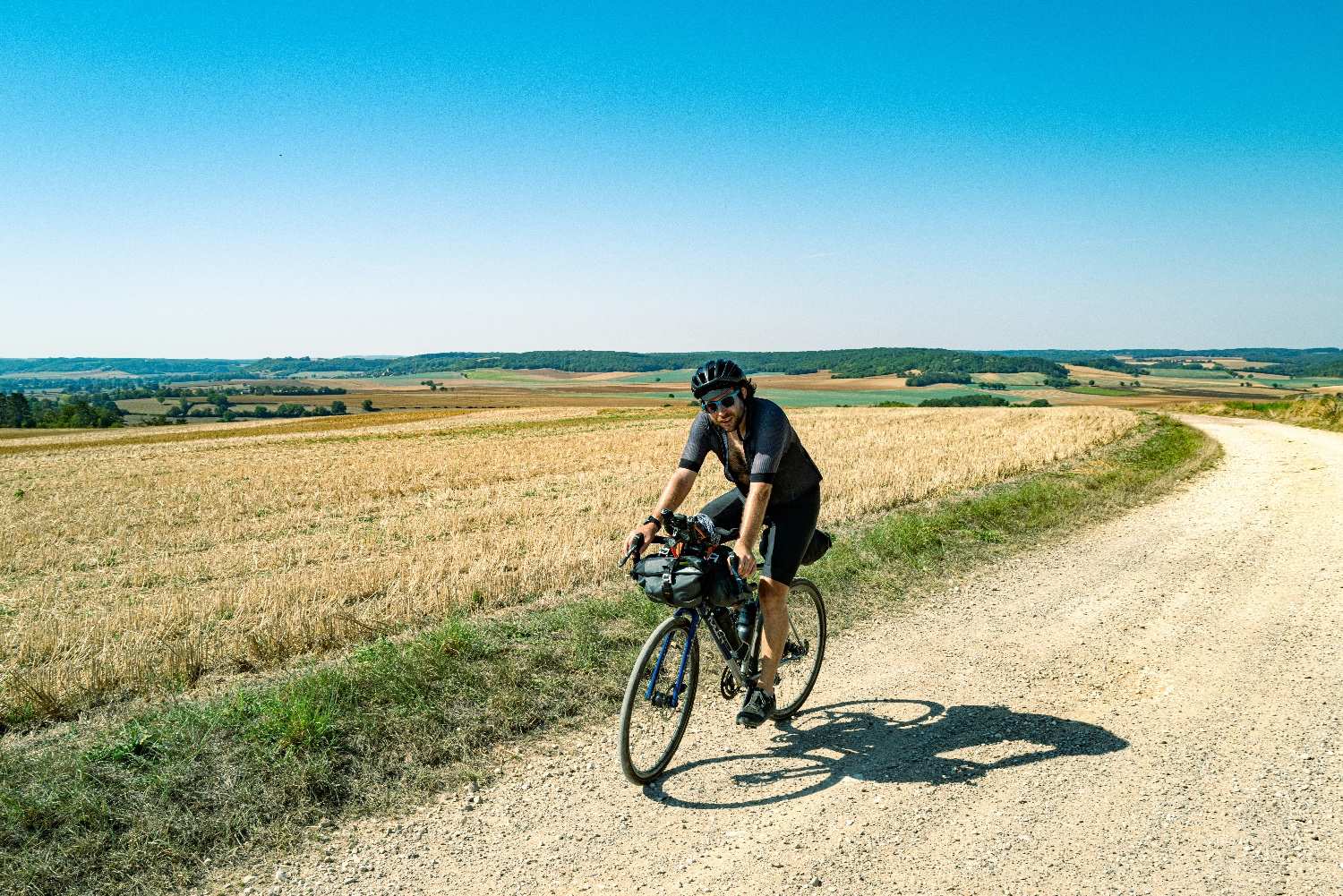 mężczyzna na wyprawie rowerowej jadący po szutrowej drodze