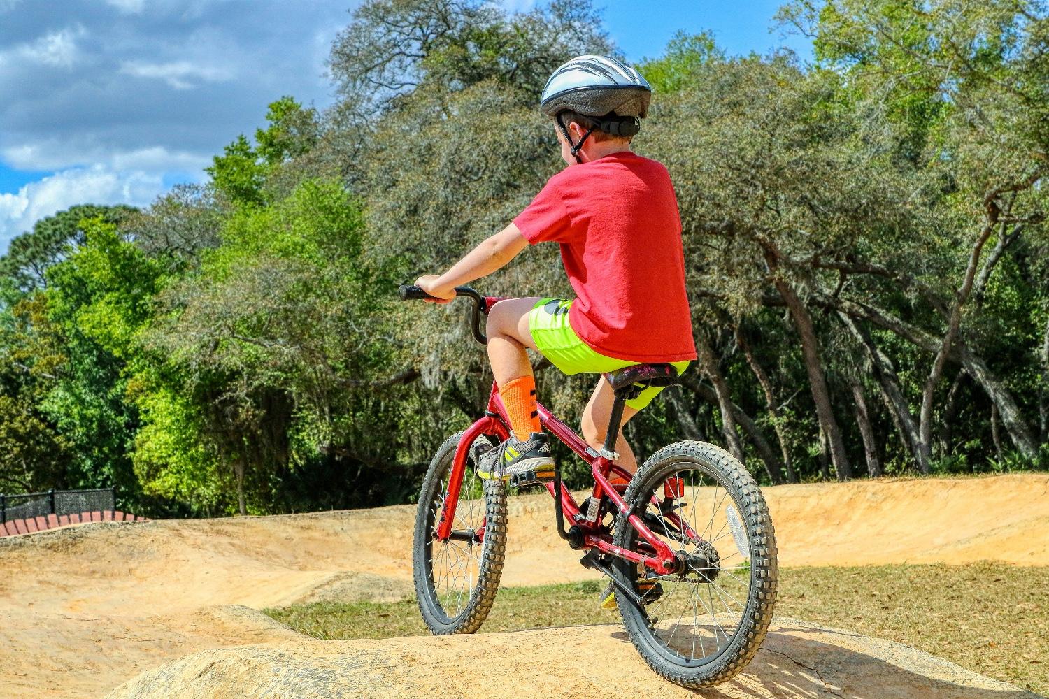 chłopiec w czerwonej koszulce na rowerze mtb junior